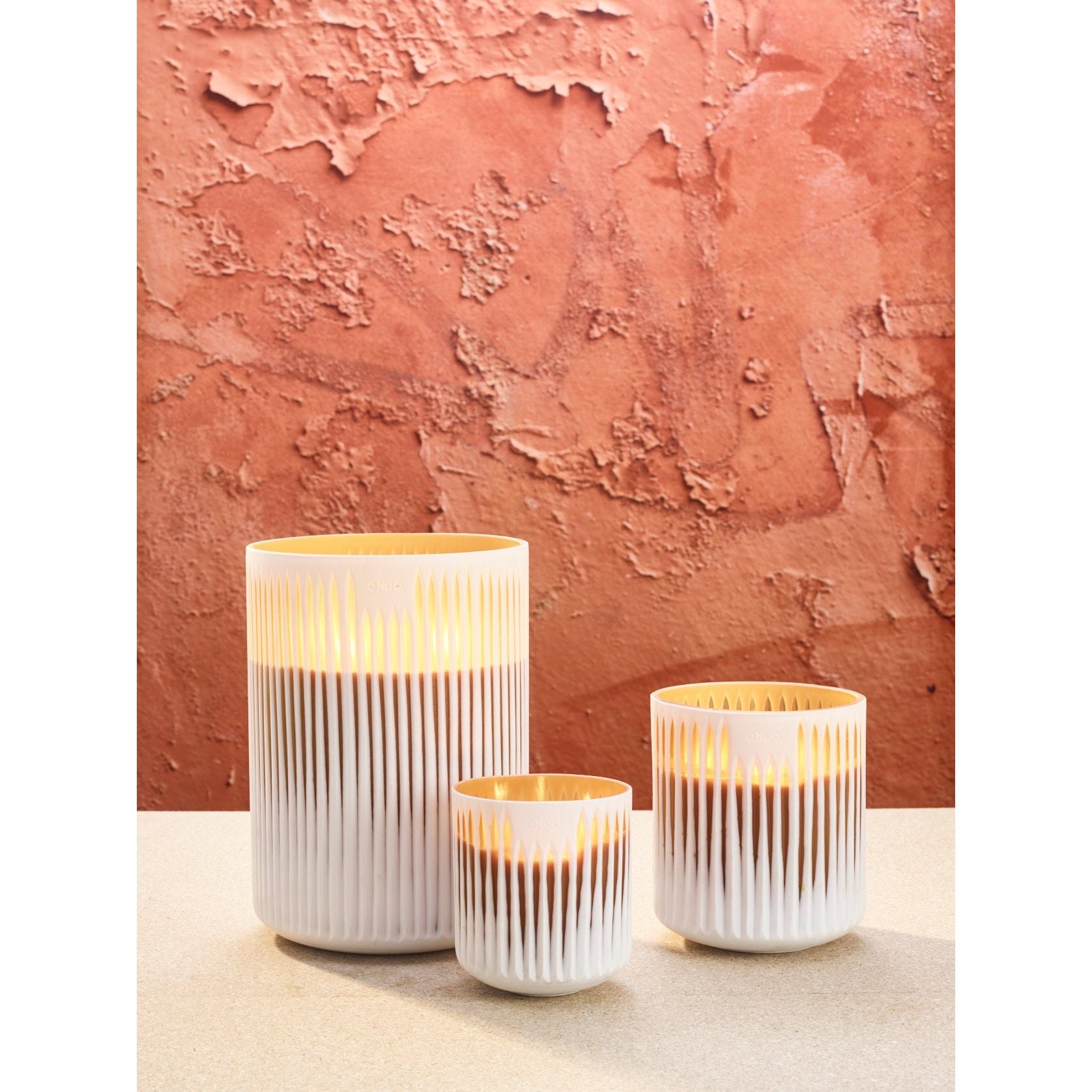 ONNO luxe geurkaarsen set Akosua Sunset brandend met terracotta achtergrond