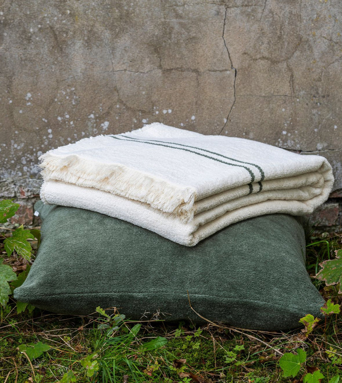 Scapa Home throw 'Piuma' with green band on green cushion