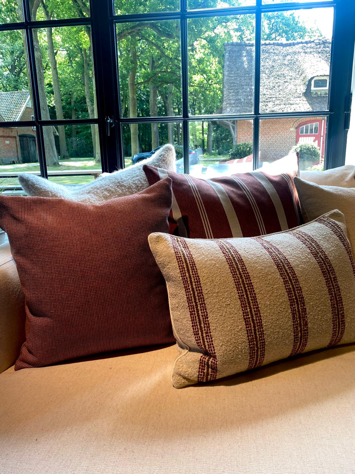 Scapa Home buitenkussens in terracotta op bank